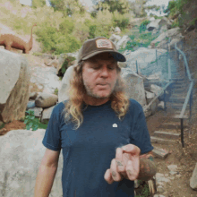 a man with long hair wearing a hat with a patch that says nsc on it