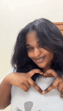 a young woman making a heart shape with her hands