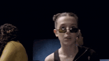 a woman wearing sunglasses is making a funny face with her mouth open .