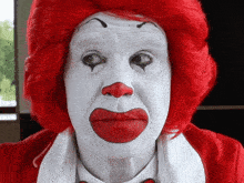 a mcdonald 's clown with red hair and white face paint