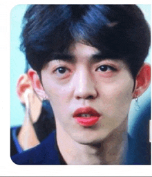a close up of a young man 's face with red lipstick .