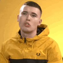 a young man wearing a yellow jacket with a black stripe on the side