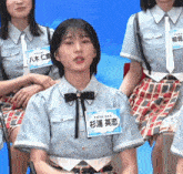 a girl in a blue shirt has a name tag that says ' ' ' ' on it