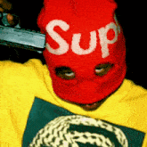 a person wearing a red mask that says sup on it