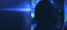a man and woman are kissing in a dark room with a blue light behind them