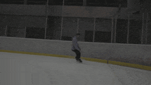 a person is ice skating on a rink with a purple shirt on
