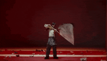 a man is holding a white flag in front of a red and white wall .
