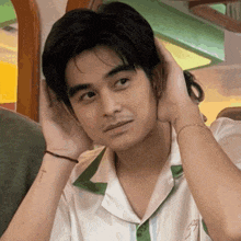 a man with a cross tattoo on his wrist is touching his head