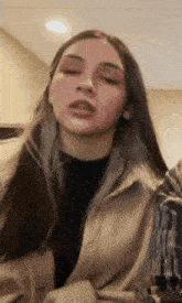 a close up of a woman 's face with her mouth open .