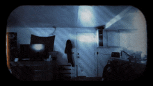 a dark room with a door and a tv