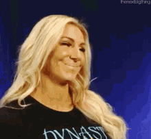 a blonde woman wearing a black shirt with the word dynasty on it .