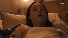a woman laying in a bed with a max logo on the bottom