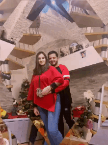 a man and a woman are posing for a picture in front of a staircase
