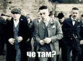 a group of men in suits are walking in a line .