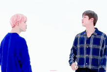 two men are standing next to each other with one wearing a plaid shirt