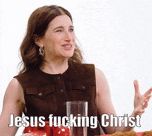 a woman sitting at a table with the words jesus fucking christ on the bottom