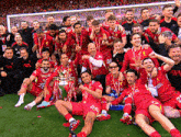 a group of soccer players are posing for a picture with the trophy