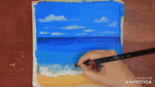a person is painting a beach scene with the words made in animotica below