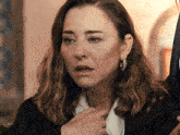 a woman with a serious look on her face is wearing hoop earrings