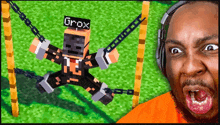 a man wearing headphones looks at a minecraft character with the name grox