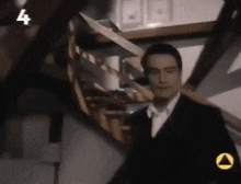 a man in a suit is walking down a set of stairs with the number 4 on the bottom