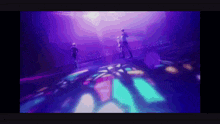 a group of people are standing on a stage in a purple light .