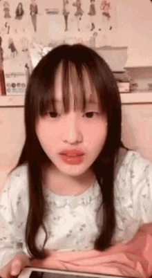 a young girl is laying on a bed looking at a tablet .