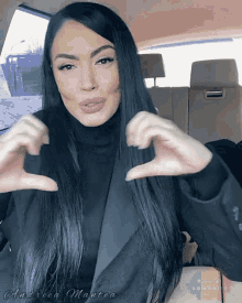 a woman in a car making a heart shape with her hands and the word andrea on the bottom right