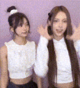 two women are standing next to each other and waving their hands .