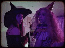 a woman in a witch costume stands next to another woman