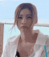 a woman in a white shirt with a blue straw in her hand