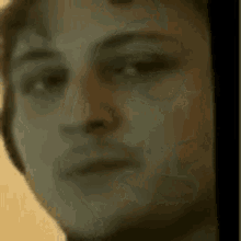 a close up of a person 's face with a blurry background .