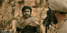 a man standing next to a horse with the words pranay and varma below him