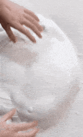 a person 's hands are reaching into a white substance