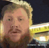 a man standing in front of a waffle house sign