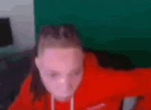 a girl in a red sweatshirt is pointing at the camera