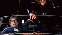 a man driving a car with a woman in the back