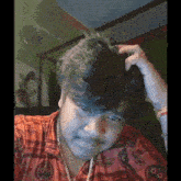 a man wearing a shirt that says ' shree ' on it is scratching his head