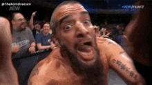 a man with a tattoo on his arm is making a funny face .