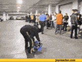 a group of people are gathered in a parking garage with joyreactor.com on the bottom