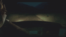 a person in a dark room looking at a car