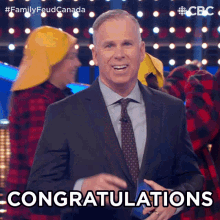a man in a suit and tie says congratulations on a stage