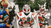 a group of kamen riders are standing next to each other in a parking lot .
