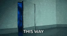 a door with a blue light coming out of it and the words " this way " on the bottom