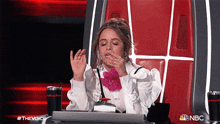 a woman is sitting in a chair with a nbc logo on the bottom