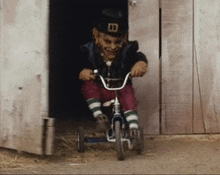 a leprechaun is riding a tricycle in front of a wooden building