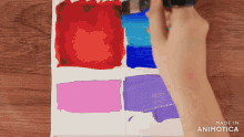 a person is painting on a canvas with a brush and the words made in animotica are visible