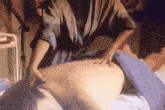 a woman in a blue robe is giving a massage to another woman