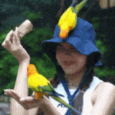 a woman wearing a blue hat and a white tank top with the letter m on it