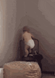 a baby in a diaper is walking on a chair .